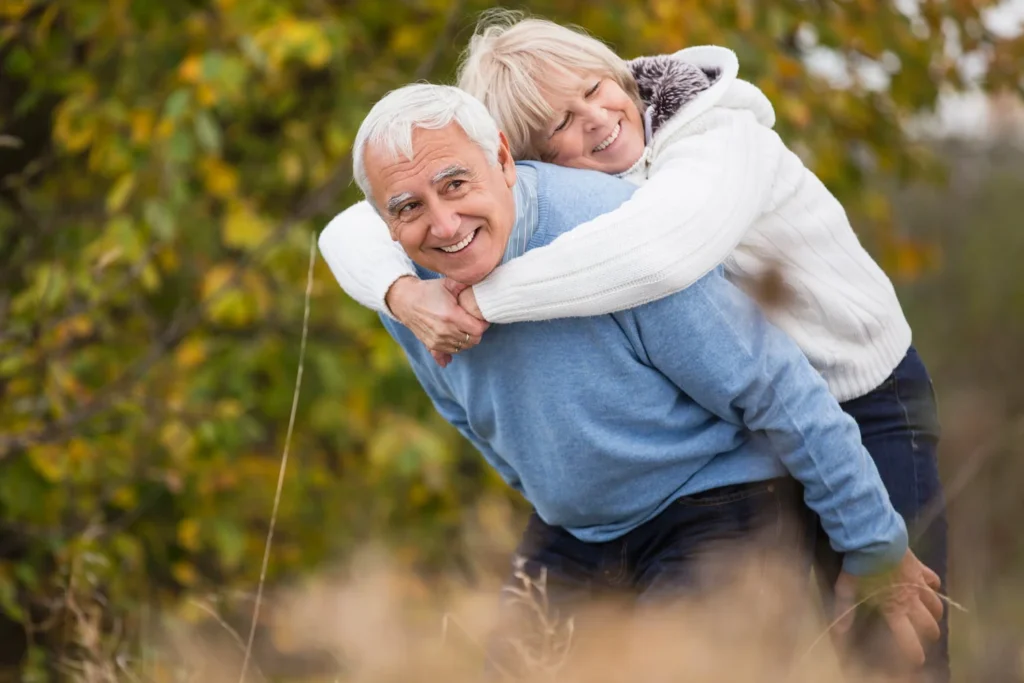 smiling-senior-giving-his-wife-a-piggyback.webp